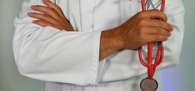 doctor holding red stethoscope by Online Marketing courtesy of Unsplash.